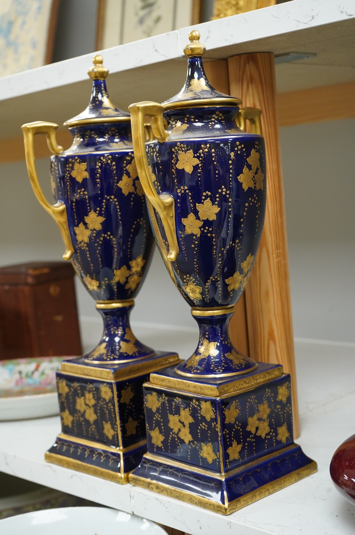 A pair of early 20th century Vienna style porcelain urns and covers, 36cm